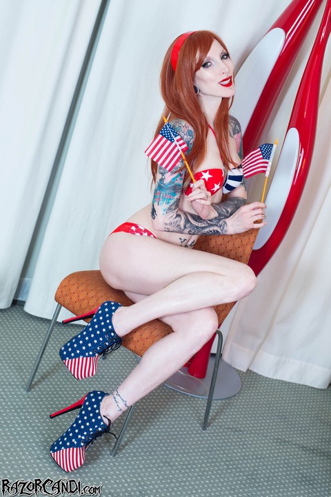 Leggy American redhead Razor Candi sports red lips while toying her bald pussy | Фото 1