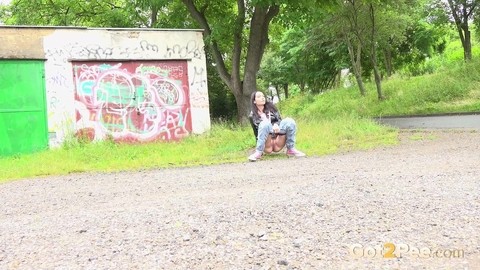 Solo girl with black hair squats for a piss on the side of a dirt road | Фото 2