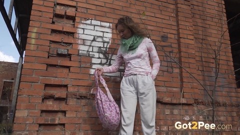 Caucasian girl Rita takes a badly needed piss behind a derelict brick building | Фото 2