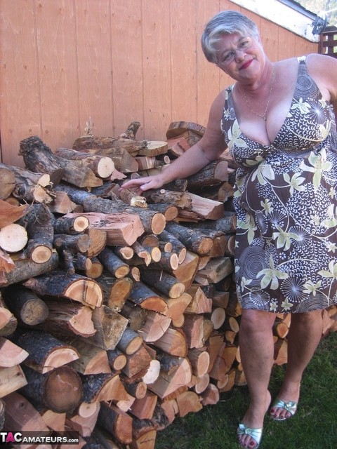 Brazen older granny strips off by the wood pile to show off BBW tits & big ass | Фото 1