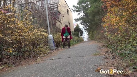 Caucasian female Lora takes a piss while walking on a pathway in the city | Фото 2