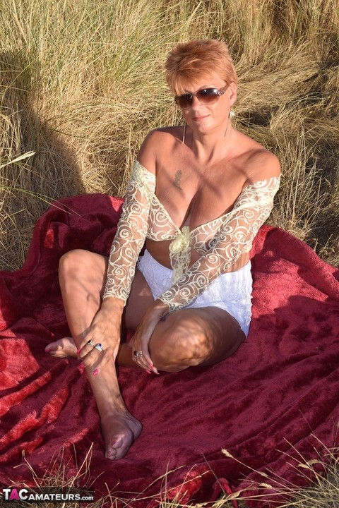 Fit older lady Dimonty exposes big naturals on a blanket overlooking the ocean | Фото 15