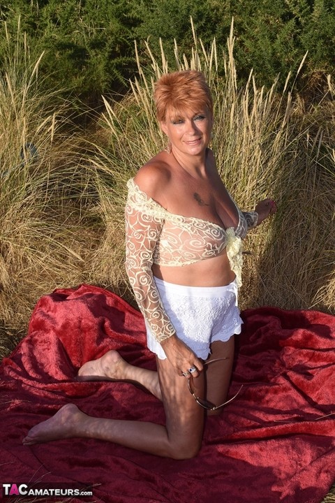 Fit older lady Dimonty exposes big naturals on a blanket overlooking the ocean | Фото 19