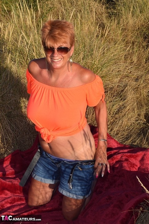 Fit older lady Dimonty exposes big naturals on a blanket overlooking the ocean | Фото 2