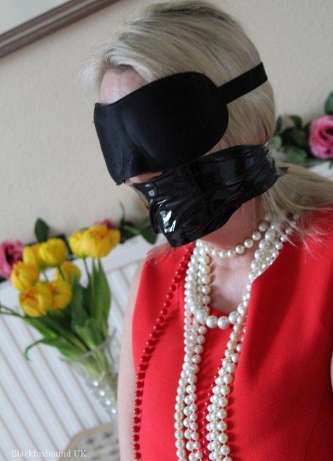 Older blonde is tied up, gagged and blindfolded in a few outfits