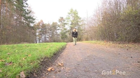 Clothed female Natasha Ink holds down her pants for a piss on a rural road | Фото 1