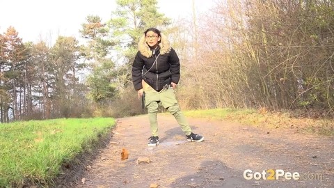 Clothed female Natasha Ink holds down her pants for a piss on a rural road | Фото 13