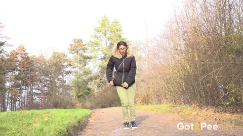 Clothed female Natasha Ink holds down her pants for a piss on a rural road | Фото 14