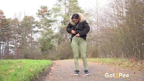 Clothed female Natasha Ink holds down her pants for a piss on a rural road | Фото 2