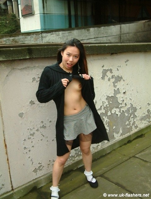 Asian girl gets naked in a skirt on a sidewalk in the United Kingdom | Фото 2