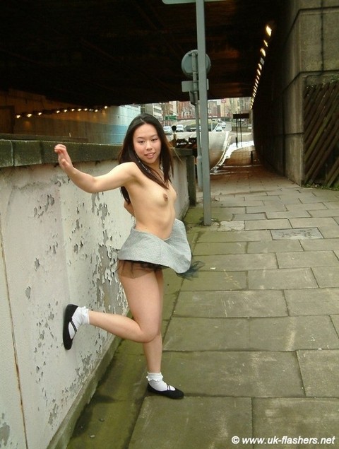 Asian girl gets naked in a skirt on a sidewalk in the United Kingdom | Фото 9