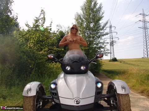 Middle-aged blonde Sweet Susi rides a three wheeled motorcycle while naked