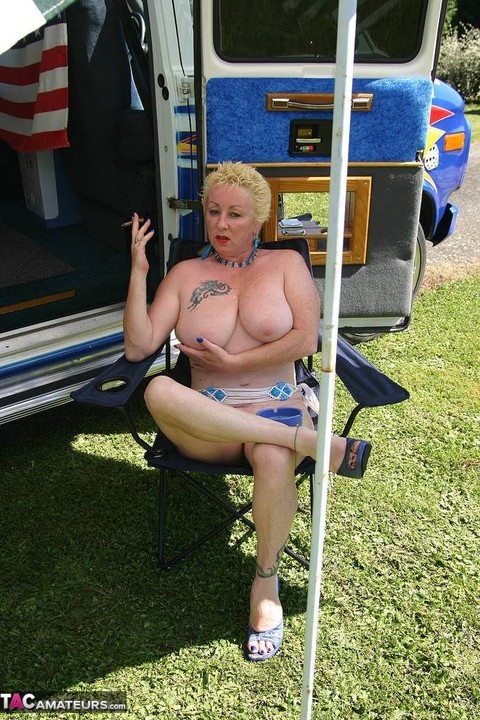 Mature blonde Mary Bitch shows her big tits and pussy outside a B class camper