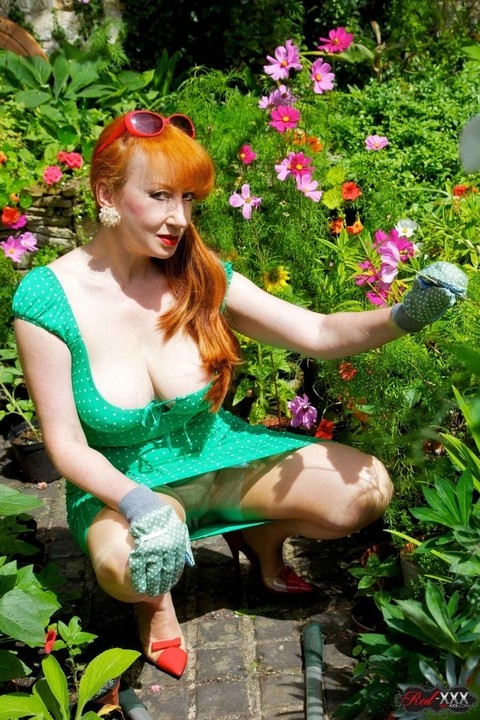 Busty redhead fingers her pussy while masturbating in a garden | Фото 2