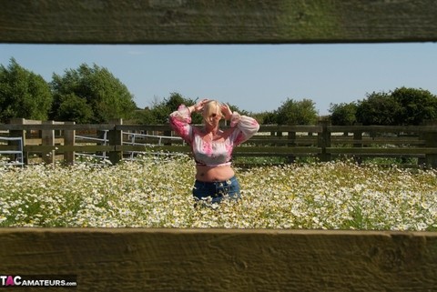 Overweight blonde Melody uncups her large boobs in a field of wild flowers | Фото 1