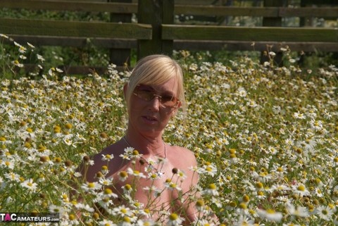 Overweight blonde Melody uncups her large boobs in a field of wild flowers | Фото 12