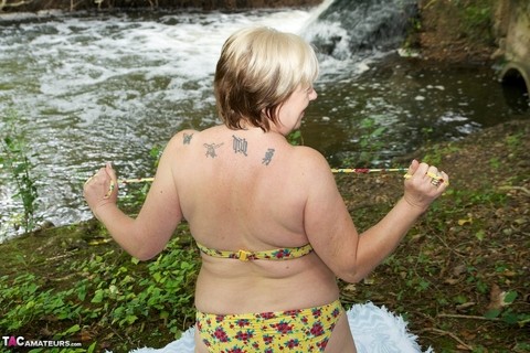 Thick mature woman Speedybee strips naked on a blanket down by the river | Фото 9