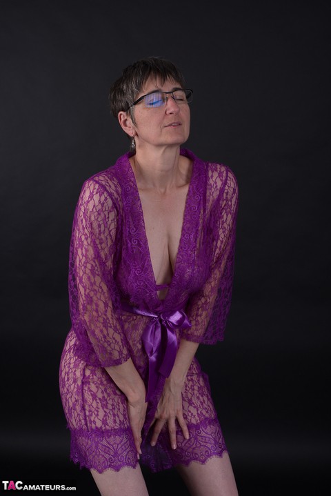 Older amateur sports short hair while modeling in purple lingerie