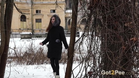 Short taken girl Vika squats for a piss on snow-covered ground in the city | Фото 1