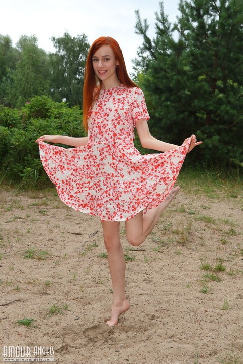 Young redhead Sherice frees her slender body from a dress not far from a river | Фото 1