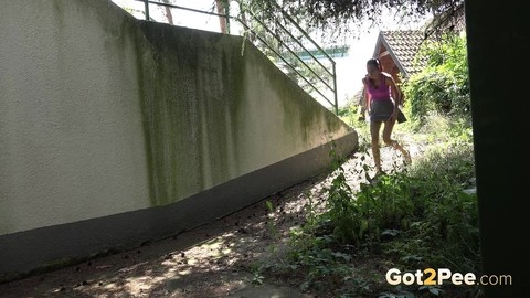 Dark haired girl Eveline Neill squats for a piss behind a building | Фото 1