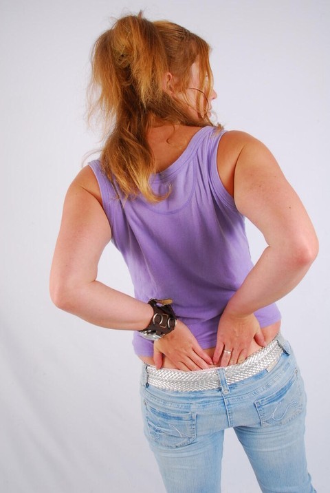 Natural redhead models a large cuff watch in a tank top and faded jeans