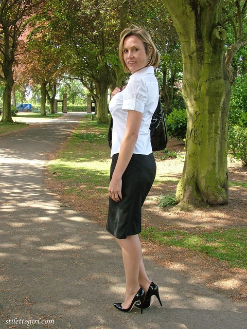 Fully clothed secretary Monica shows off hose clad legs in pumps on pathway