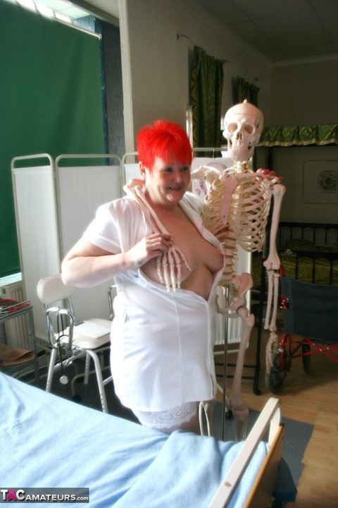 Slutty mature nurse in white stockings gets toyed up by a skeleton | Фото 14