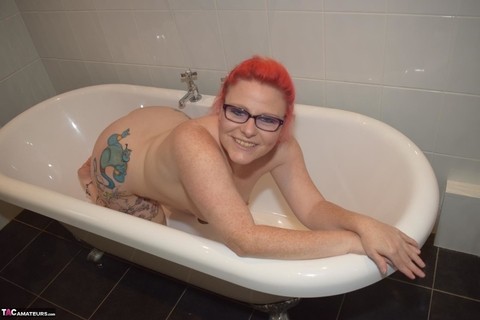 Older redhead Mollie Foxxx displays her tattooed body in the bathroom | Фото 10