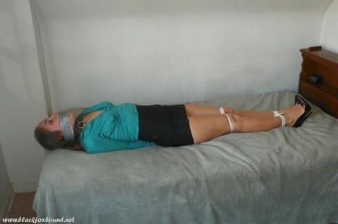 Collared woman is tied up on a bed in a black miniskirt and pumps | Фото 14