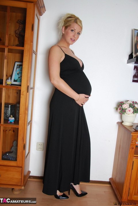 Pregnant blonde beauty drops gown to reveal her swollen belly & full milkers | Фото 1