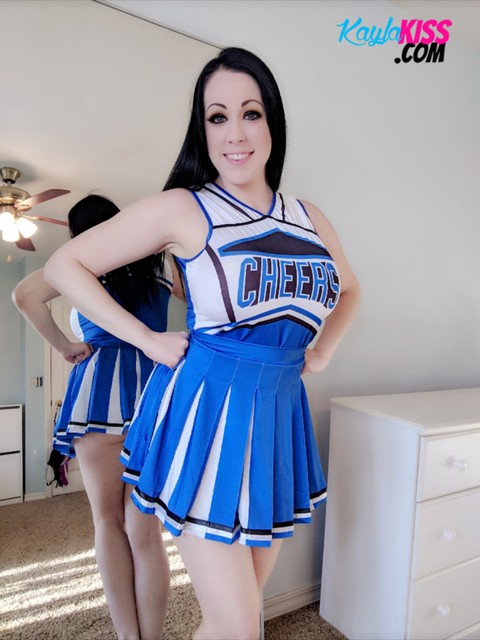 Dark-haired cheerleader Kayla Kiss uncovers her big natural tits in OTK socks | Фото 2