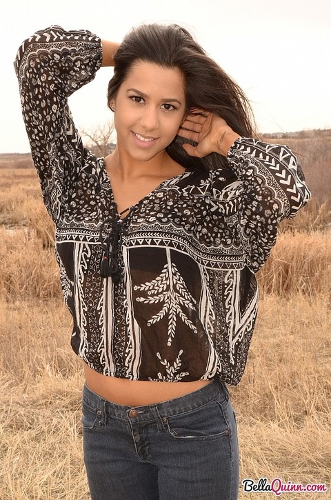 Latina girl Bella Quinn models in a field wearing a bra and jeans | Фото 1