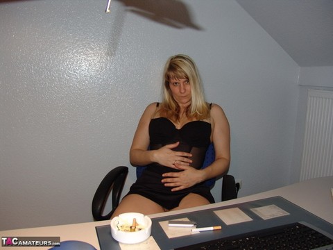 Mature amateur smokes a cigarette before masturbating in office chair | Фото 2