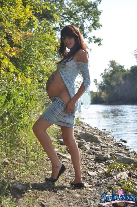 Solo girl Brianna exposes her pregnant belly on rocky shore beside a river | Фото 3