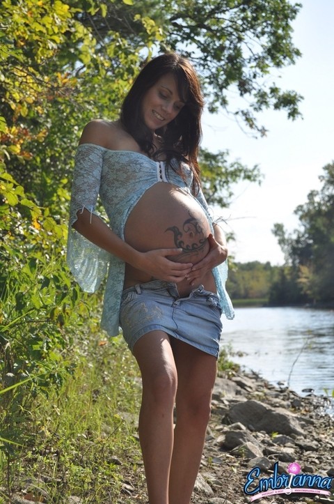 Solo girl Brianna exposes her pregnant belly on rocky shore beside a river | Фото 5