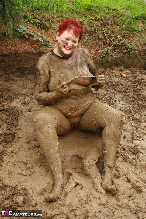 Older redhead Valgasmic Exposed rolls around in a mud pit while totally naked | Фото 14