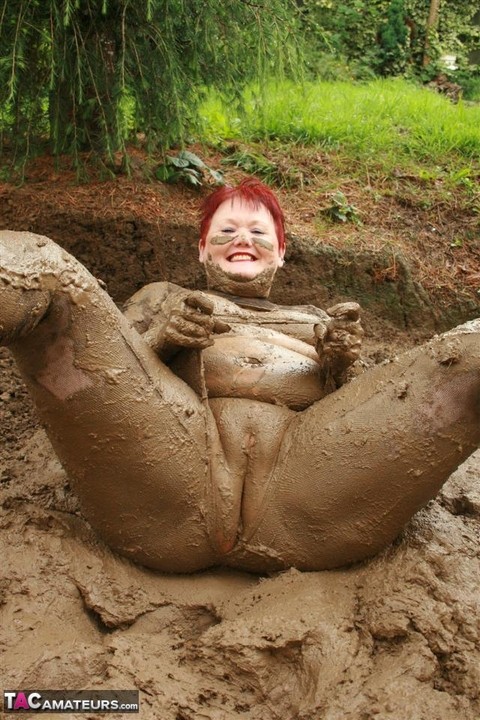 Older redhead Valgasmic Exposed rolls around in a mud pit while totally naked | Фото 15