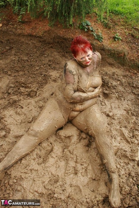 Older redhead Valgasmic Exposed rolls around in a mud pit while totally naked | Фото 16