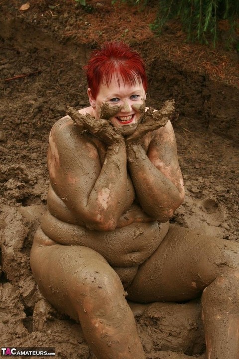 Older redhead Valgasmic Exposed rolls around in a mud pit while totally naked | Фото 19