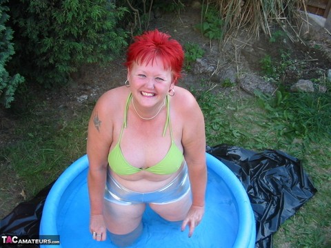 Older redheaded BBW Valgasmic Exposed plays with a dildo in a wading pool