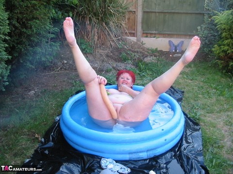 Older redheaded BBW Valgasmic Exposed plays with a dildo in a wading pool | Фото 7