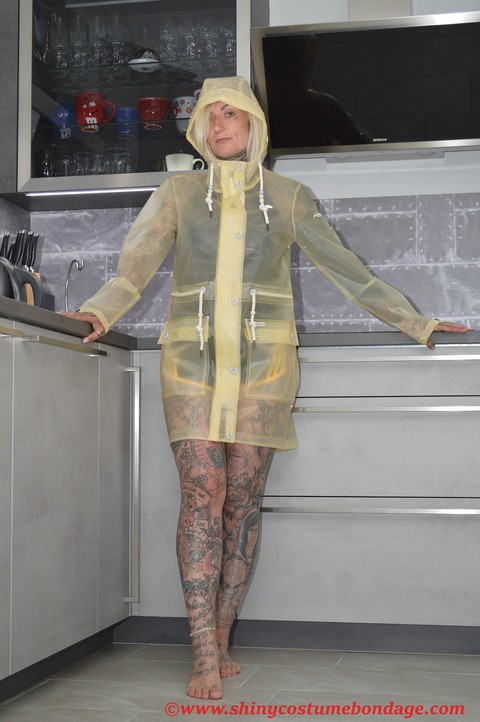 Tattooed blonde Miss Francine models barefoot in a raincoat over rubber wear | Фото 2