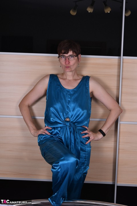 Amateur woman models satin evening wear on a bed with her glasses on | Фото 2