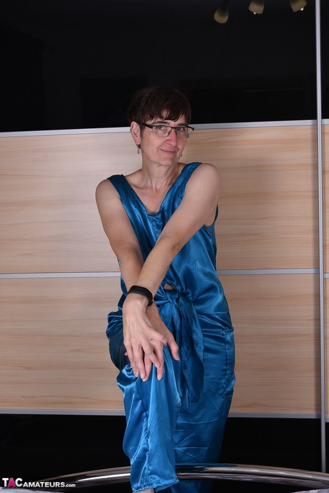 Amateur woman models satin evening wear on a bed with her glasses on | Фото 4