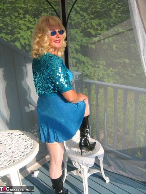 Mature blonde Ruth models a bra and skirt in boots and shades on a deck | Фото 14