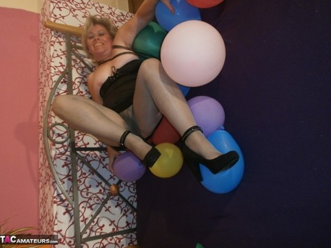 Hot granny Caro in shiny sheer pantyhose & heels crushing balloons on her bed | Фото 18