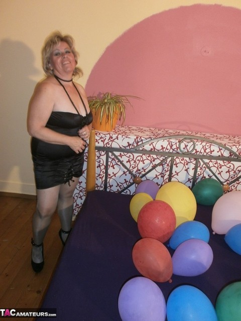 Hot granny Caro in shiny sheer pantyhose & heels crushing balloons on her bed | Фото 4