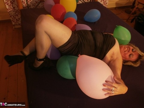 Hot granny Caro in shiny sheer pantyhose & heels crushing balloons on her bed | Фото 8