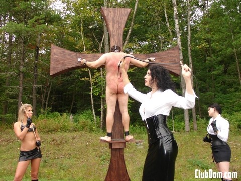 Three skinny dommes whip their sex slave tied up to an outdoor cross | Фото 11